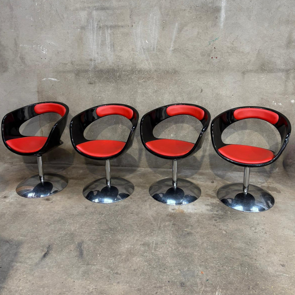 Fauteuil rétro avec pied chromé, assise plastic noir et cuir rouge sélectionné par Déco à deux